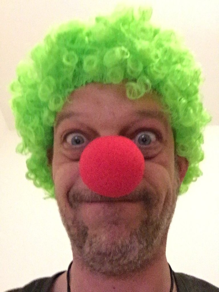 Michael mit roter Clown-Nase und grüner Lockenperücke